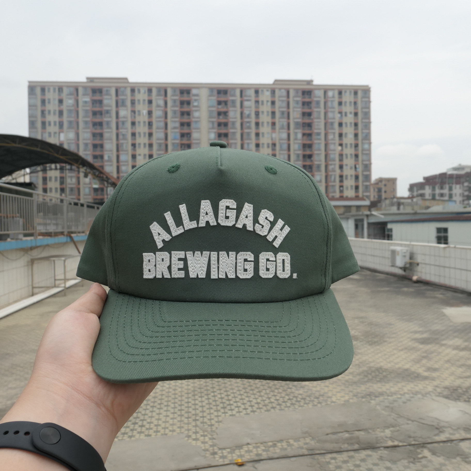 Green Allagash cap with cream felt lettering