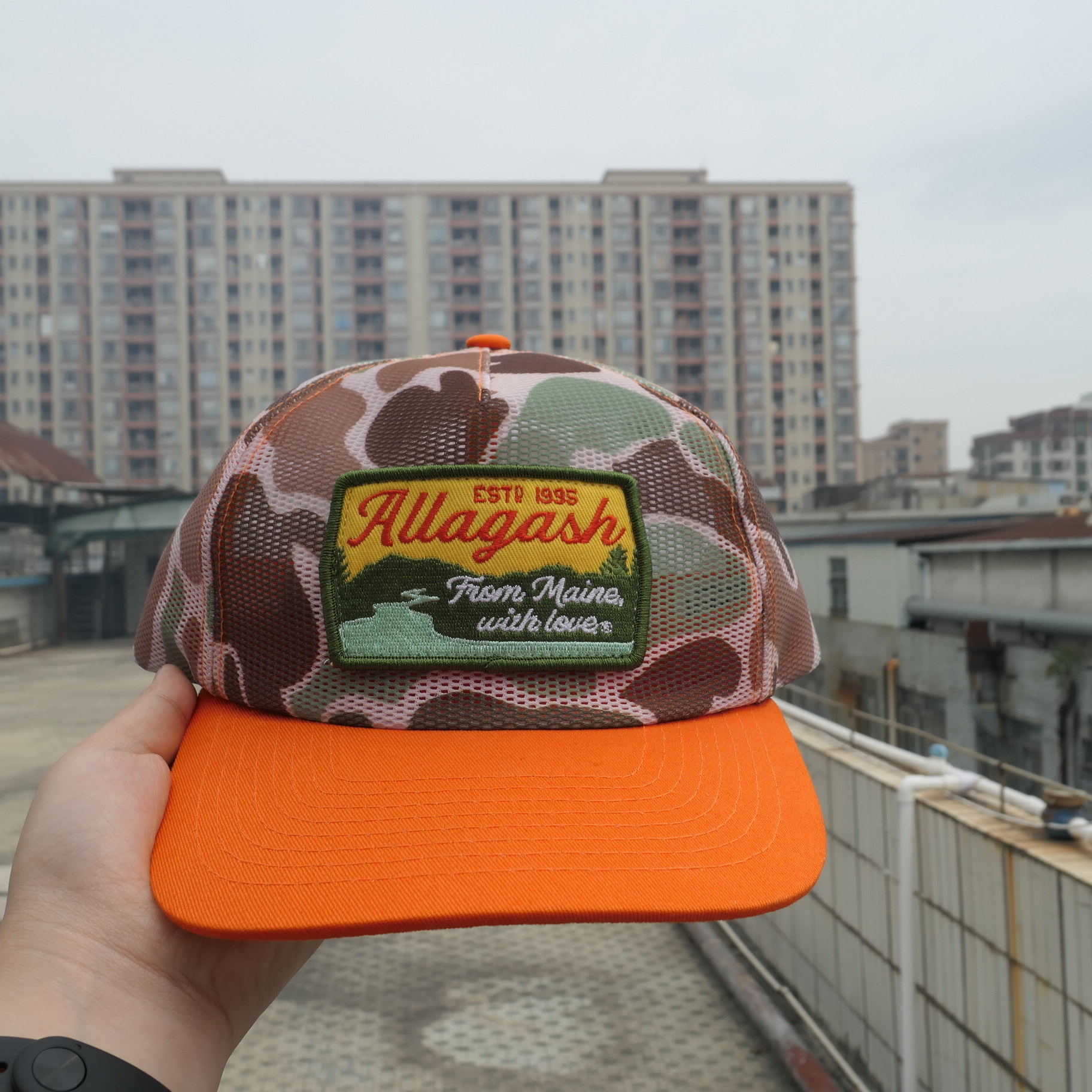 Camo and orange Allagash mesh cap with a colorful patch