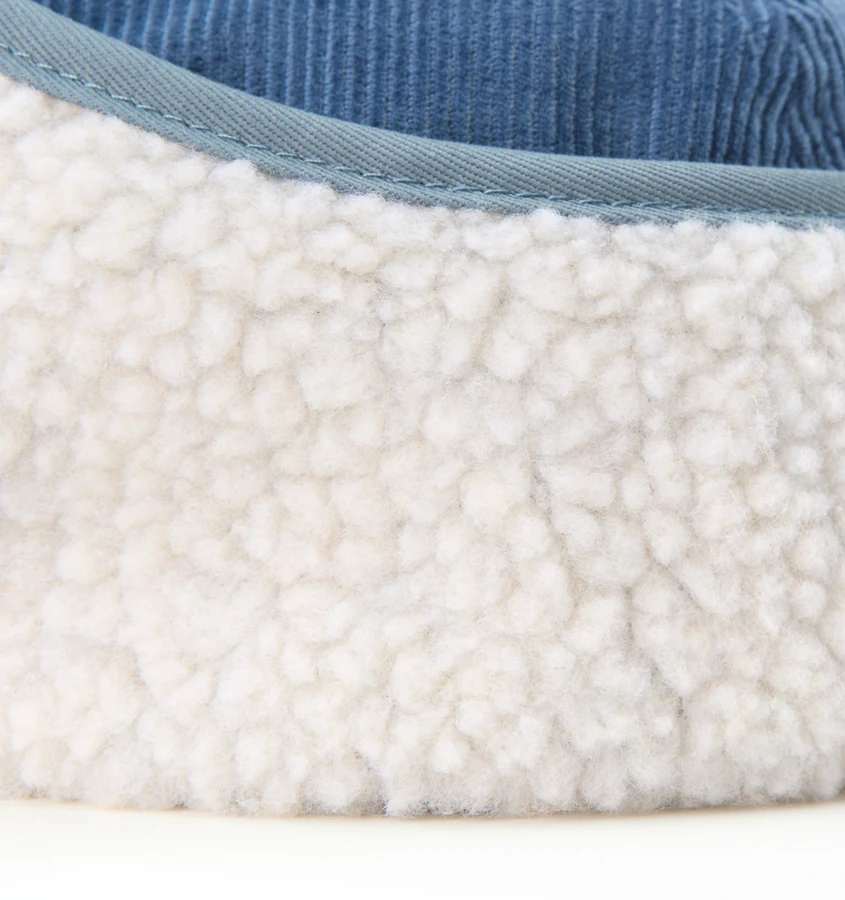 Close-up of soft cream fleece lining with blue fabric binding